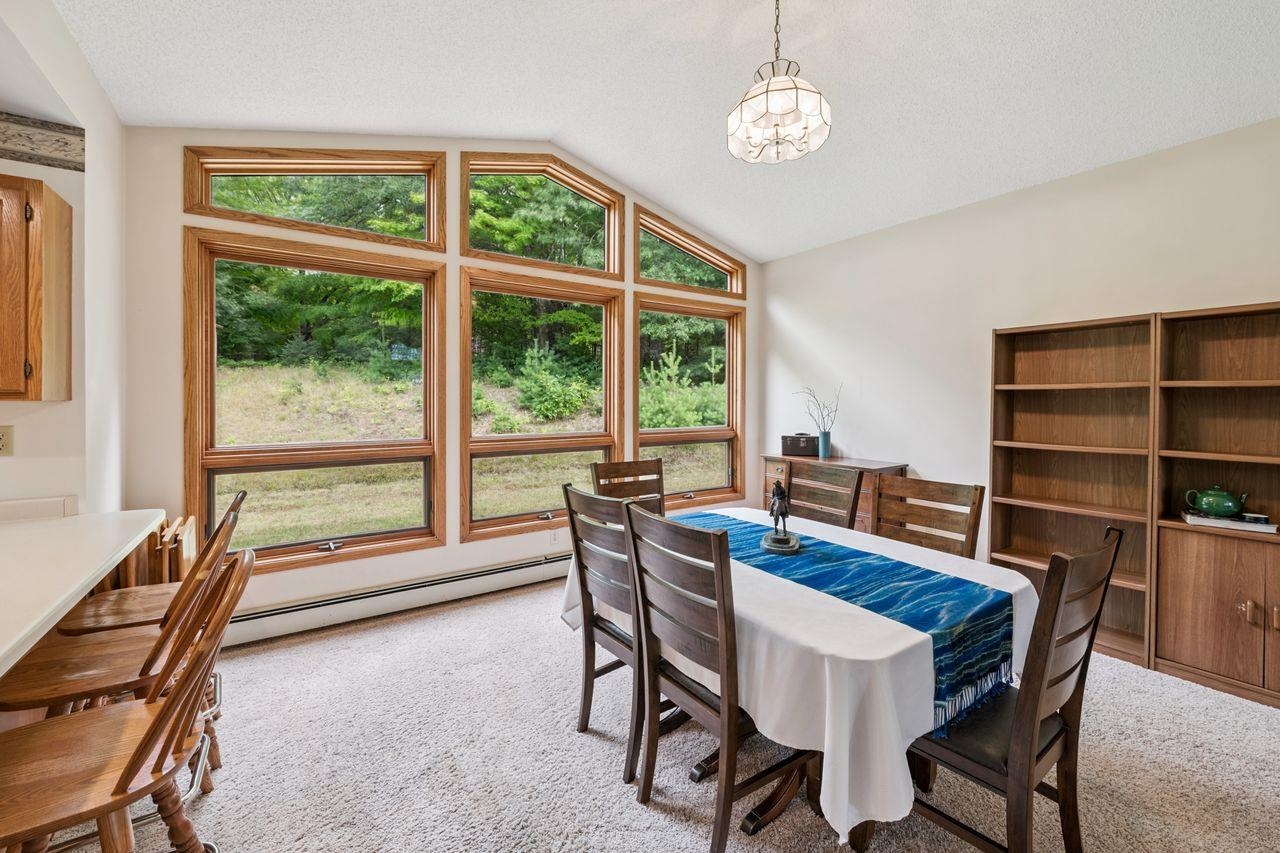 75920 Ondossagon Road Washburn, WI 54891 - Photo 5 of 29 Dining room featuring lofted ceiling, a baseboard radiator, light carpet, and a textured ceiling