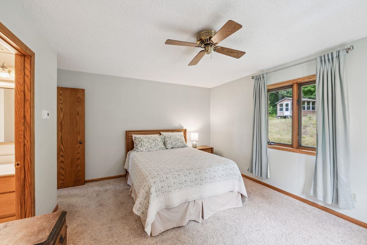 75920 Ondossagon Road Washburn, WI 54891 - Photo 9 of 29 Carpeted bedroom featuring a textured ceiling and a ceiling fan