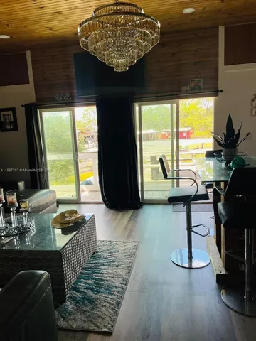 a living room with couches painting on the wall and a large window