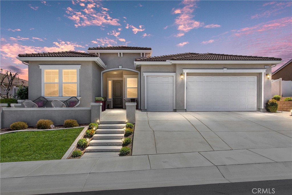 a front view of a house with a yard and a garden