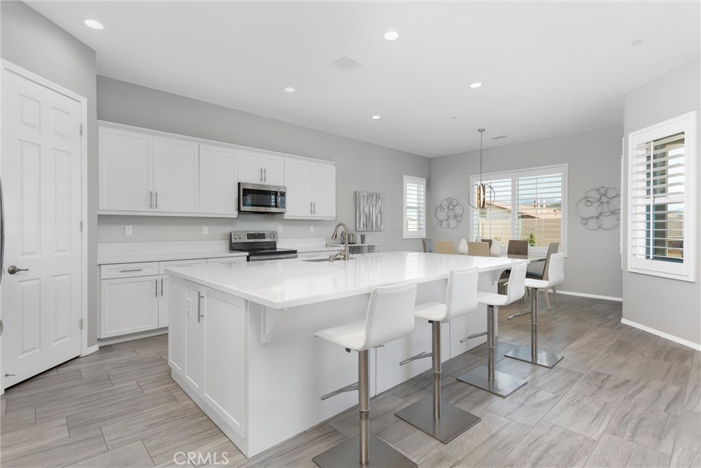 1545 Rio Grande Beaumont, CA 92223 - Photo 8 of 34 a kitchen with stainless steel appliances a stove a sink a microwave a refrigerator and cabinets