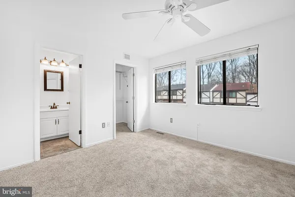 an empty room with closet and fan