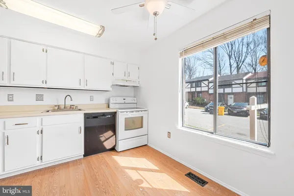 a kitchen with granite countertop white cabinets and white appliances