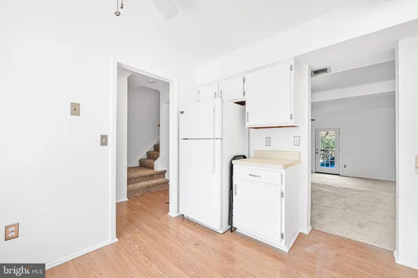 a view of a kitchen with refrigerator and wooden floor