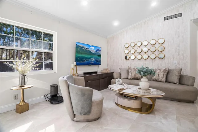 a living room with furniture a flat screen tv and a table