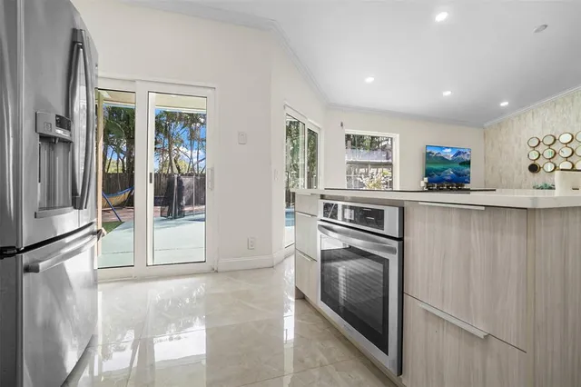 a kitchen with granite countertop a refrigerator and a stove top oven