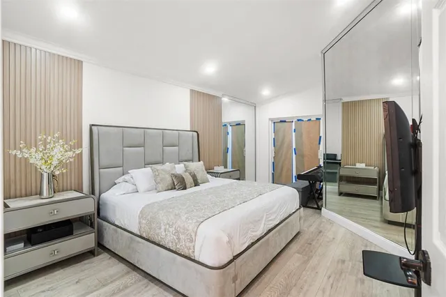 a bedroom with a large bed and a flat screen tv