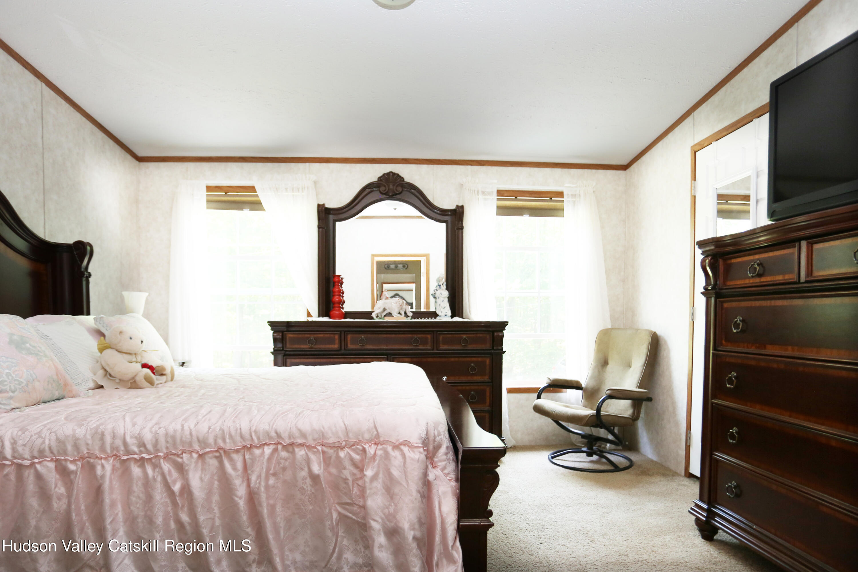 219 Edison Timmerman Road Cairo, NY 12413 - Photo 21 of 51 a bedroom with a bed a flat screen tv and a dresser with the mirror