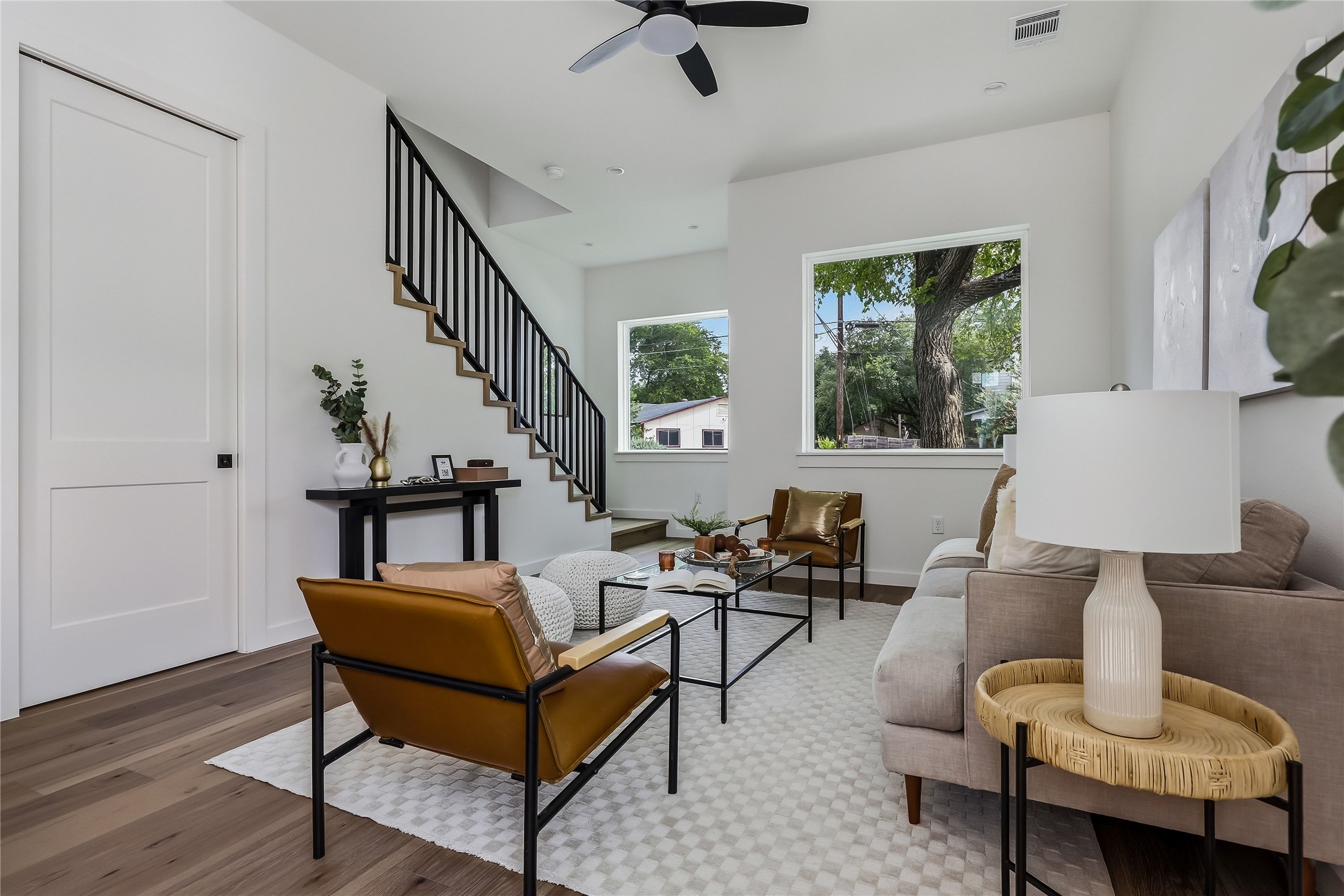 6809 Porter Street, Unit 1 Austin, TX 78741 - Photo 5 of 40 A contemporary living area with engineered hardwood floors and a modern staircase creates an inviting atmosphere.