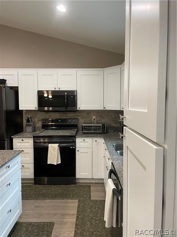 13591 Southwest 112th Street Dunnellon, FL 34432 - Photo 5 of 24 a kitchen with a refrigerator stove and white cabinets