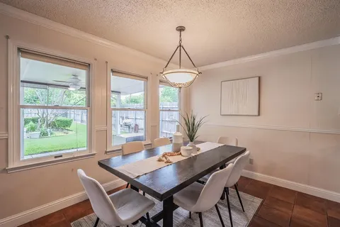 a dining room with wooden floor a chandelier a wooden table and chairs
