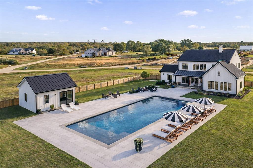 a view of a house with pool and chairs
