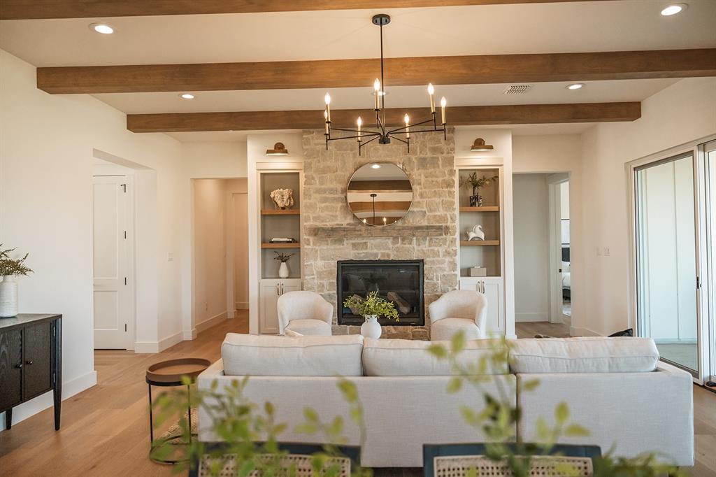 1070 Browning Road Argyle, TX 76226 - Photo 2 of 21 Living area featuring a stone fireplace, hanging lights, wood finished floors, and beamed ceiling