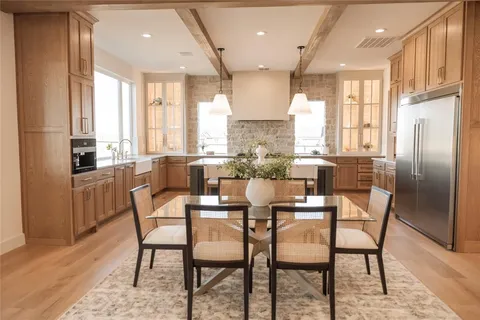 a dining room with furniture a large window and stainless steel appliances