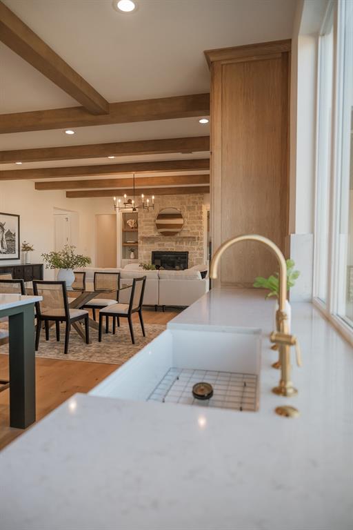 1070 Browning Road Argyle, TX 76226 - Photo 21 of 21 Kitchen with a fireplace, light wood finished floors, beam ceiling, open floor plan, and hanging lights