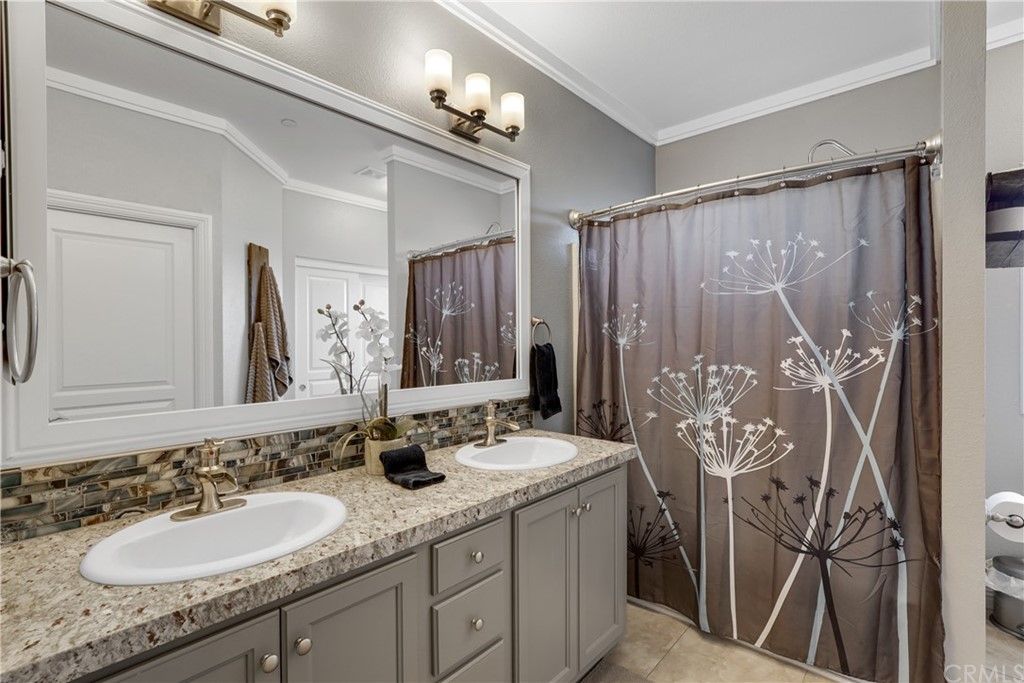 60600 Burnt Valley Road Anza, CA 92539 - Photo 17 of 46 a bathroom with double vanity sinks a toilet a mirror a vanity and shower