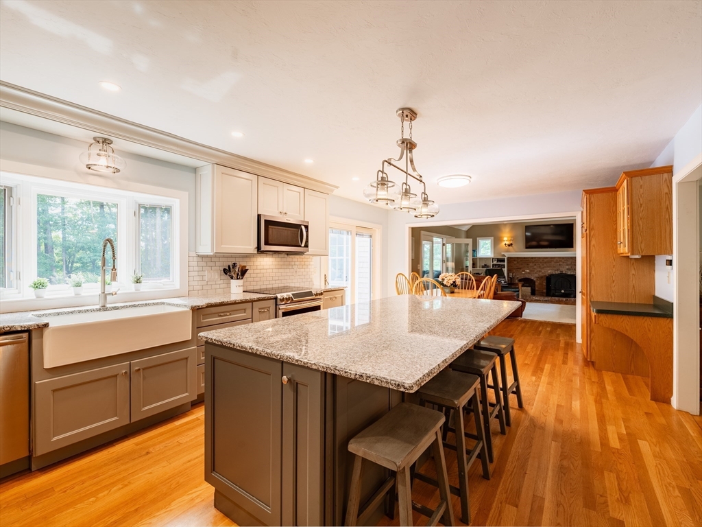 17 Gardner Road Duxbury, MA 02332 - Photo 11 of 42 a kitchen with stainless steel appliances granite countertop a stove top oven a sink dishwasher and a refrigerator with wooden floor