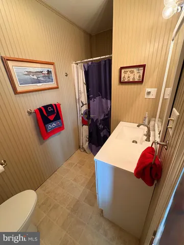 a bathroom with a sink mirror and a toilet