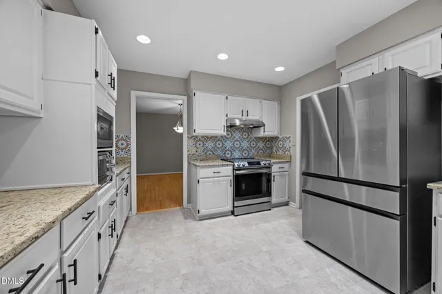 a kitchen with granite countertop a refrigerator and a sink