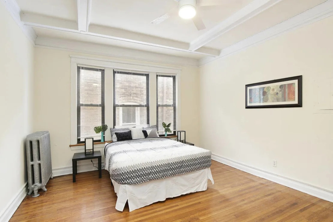 5124 South University Avenue Chicago, IL 60615 - Photo 7 of 8 a spacious bedroom with a bed and a large window