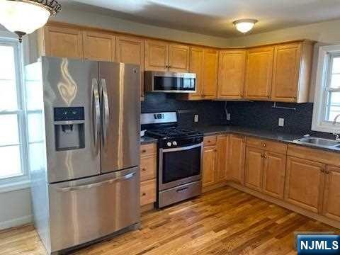 22 Broadway, Unit 2 Hackensack, NJ 07601 - Photo 2 of 8 a kitchen with granite countertop a refrigerator stove and sink