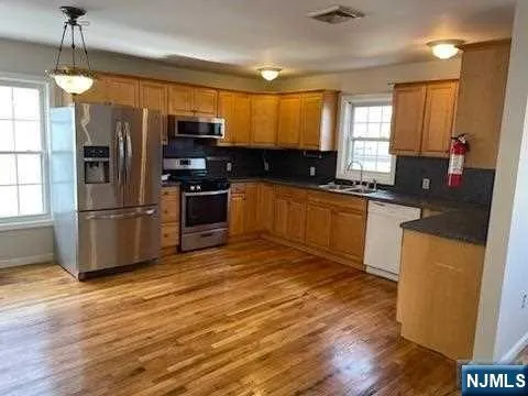 a kitchen with granite countertop a refrigerator stove top oven and sink