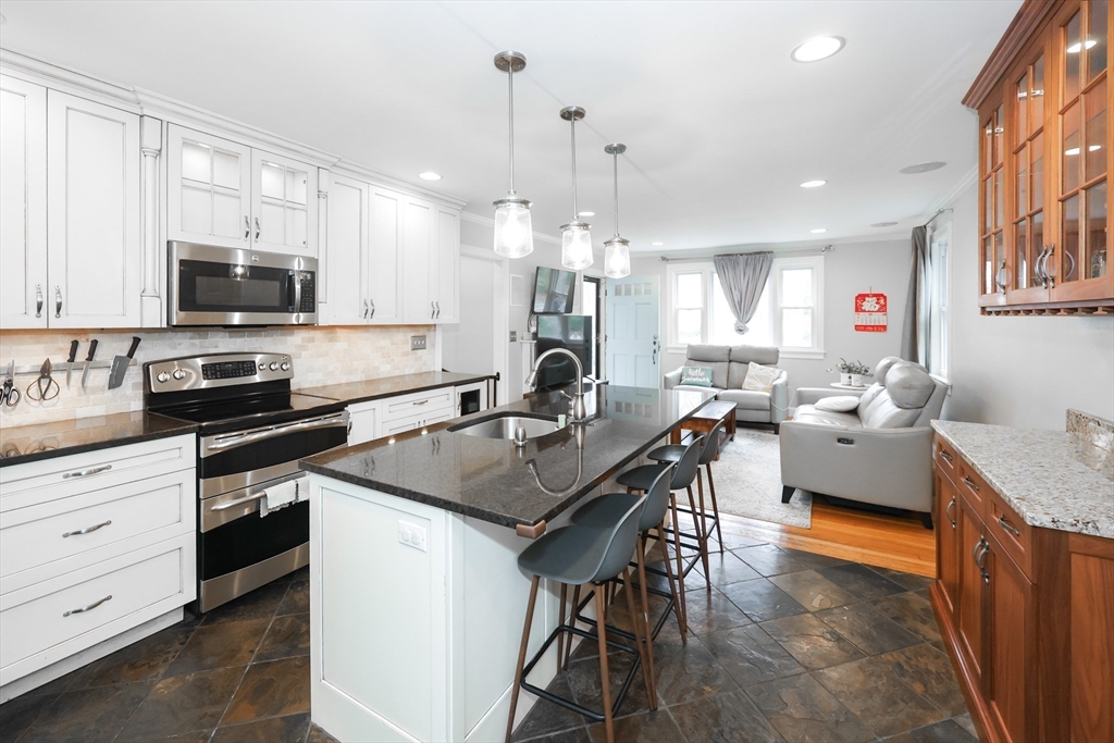 170 New Estate Road Littleton, MA 01460 - Photo 8 of 28 a kitchen with stainless steel appliances granite countertop a stove top oven a sink dishwasher a dining table and chairs with wooden floor