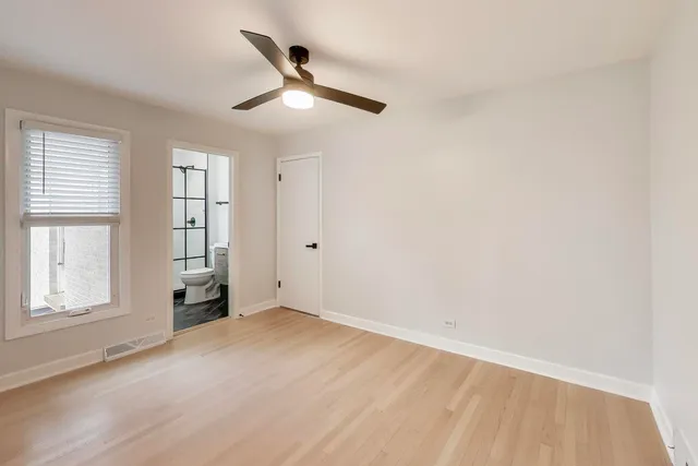an empty room with windows and ceiling fan