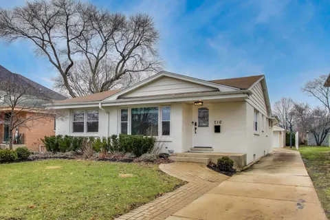 a view of a white house with a yard and plants