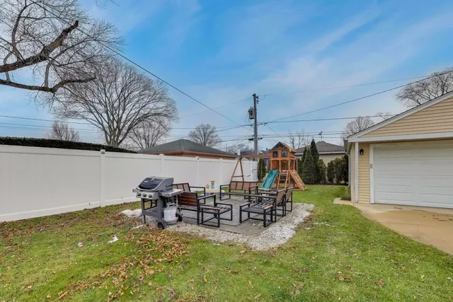 a view of a chairs and table in patio with a wooden fence