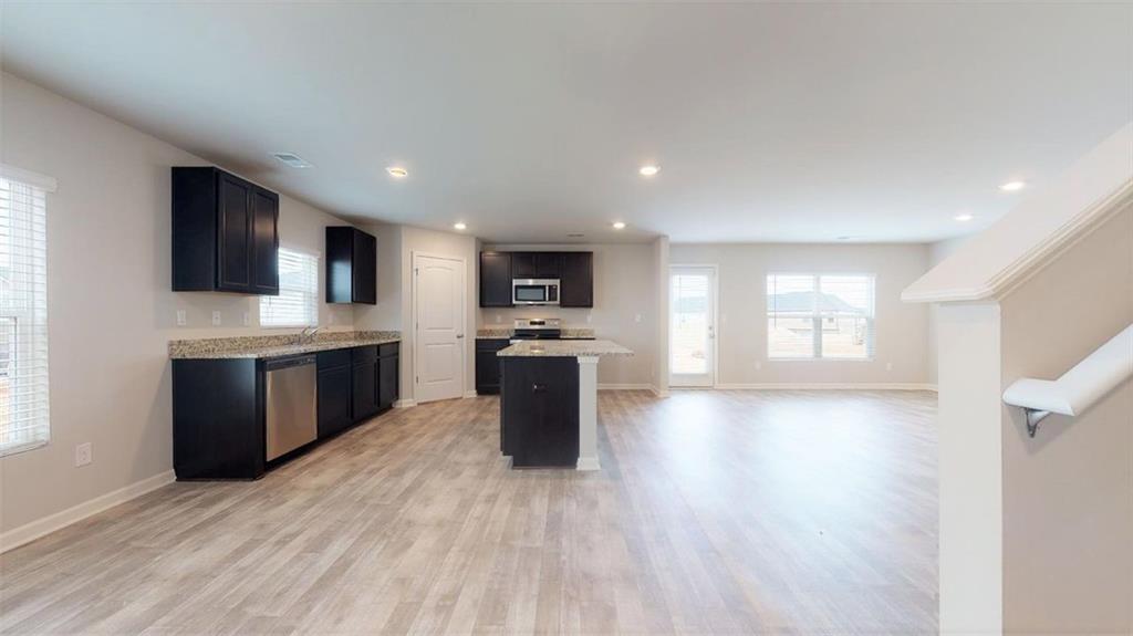 121 Weldon Road McDonough, GA 30253 - Photo 14 of 32 a large kitchen with stainless steel appliances kitchen island granite countertop a sink dishwasher a stove and a refrigerator with wooden floor