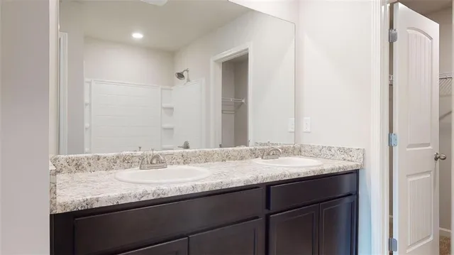 a bathroom with a granite countertop sink and a mirror