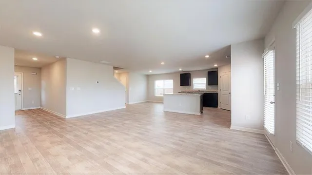 a view of kitchen with kitchen island a sink wooden floor and a refrigerator