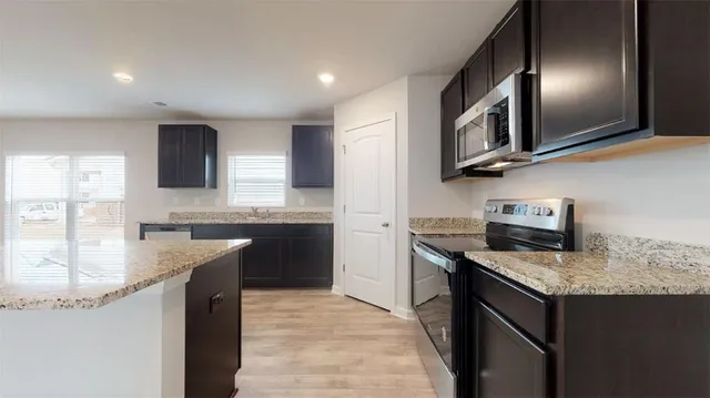 a kitchen with granite countertop stainless steel appliances and sink