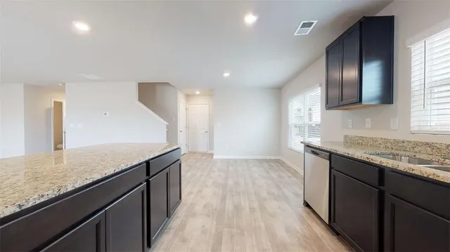 a kitchen with granite countertop kitchen island wooden floors granite counter tops and a window