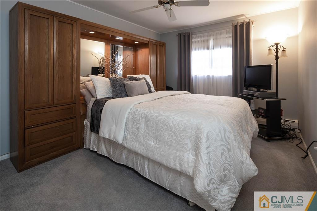 207 South Hill Road Colonia, NJ 07067 - Photo 19 of 47 a spacious bedroom with a bed and a flat tv screen on dresser