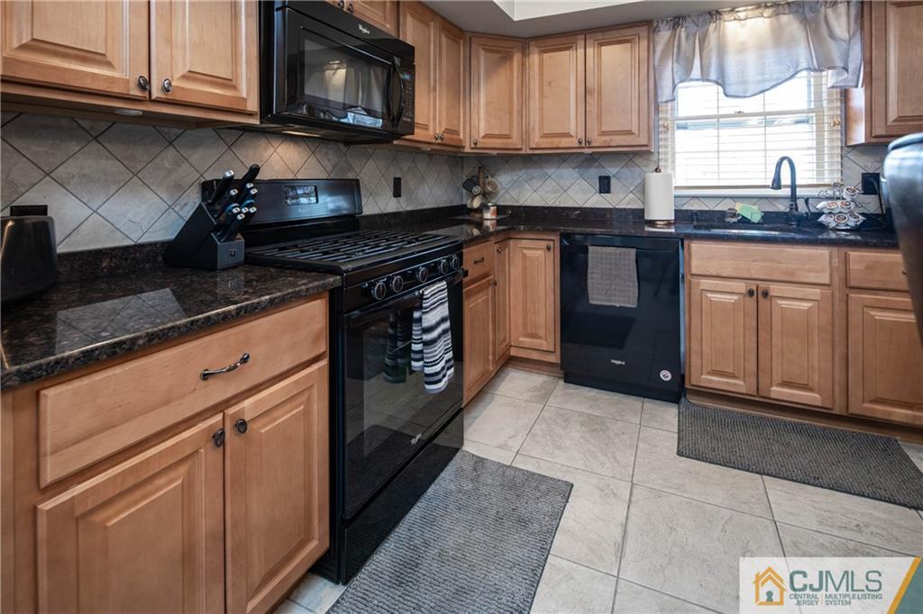 207 South Hill Road Colonia, NJ 07067 - Photo 8 of 47 a kitchen with stainless steel appliances granite countertop a stove a sink and a microwave