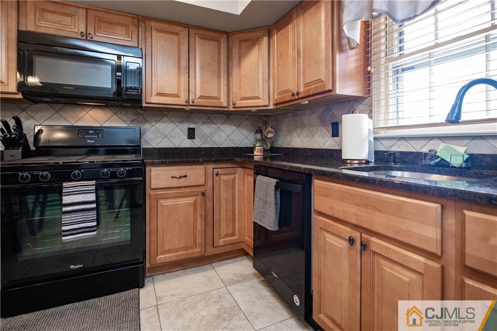 207 South Hill Road Colonia, NJ 07067 - Photo 9 of 47 a kitchen with stainless steel appliances granite countertop a stove a sink and a microwave