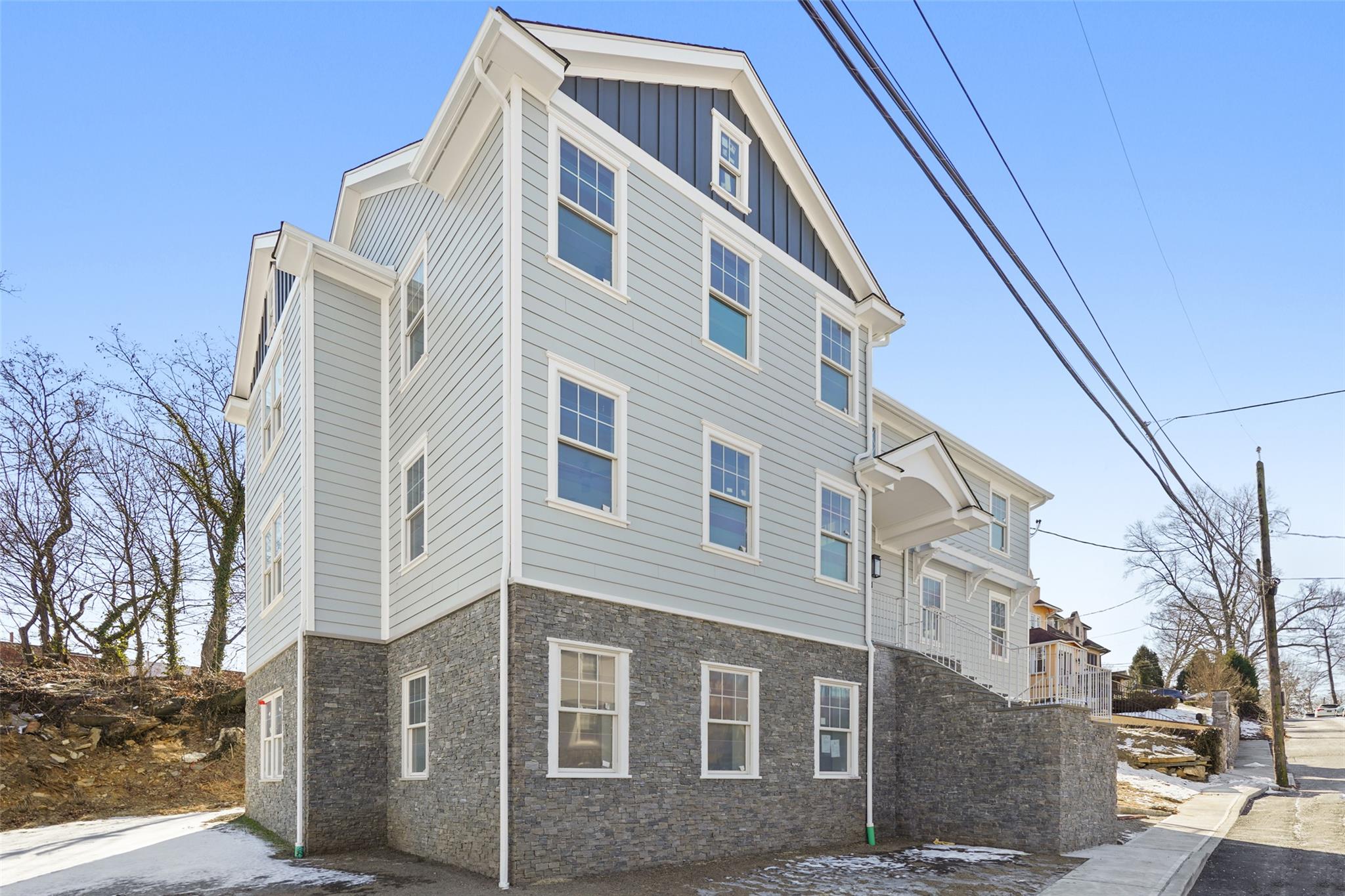 View of side of property featuring stone siding and board and batten siding