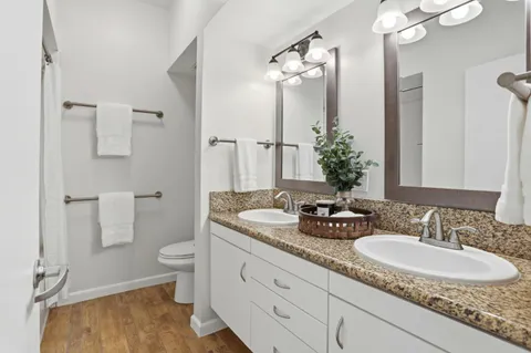a view of a hallway with wooden floor and stairs