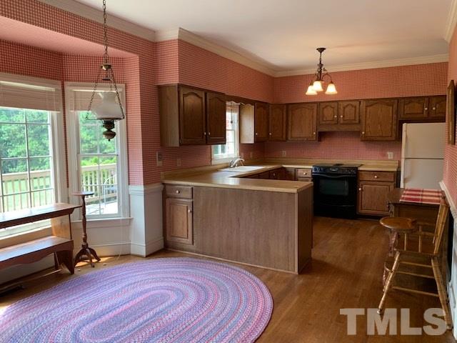 717 Brookfield Road Raleigh, NC 27615 - Photo 13 of 30 a kitchen with kitchen island a counter top a stove a sink and a refrigerator
