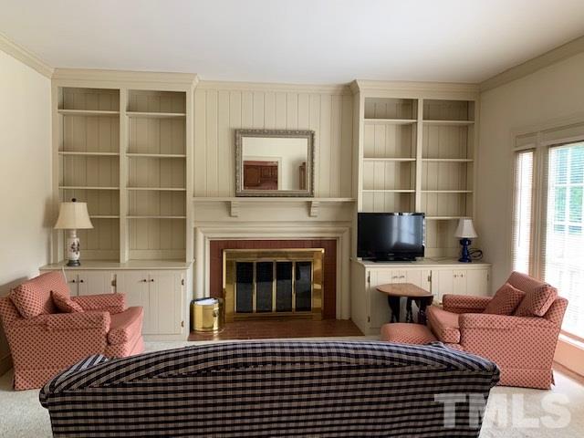 717 Brookfield Road Raleigh, NC 27615 - Photo 17 of 30 a living room with furniture a fireplace and a flat screen tv