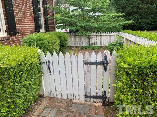 717 Brookfield Road Raleigh, NC 27615 - Photo 3 of 30 a view of a small yard with plants and wooden fence