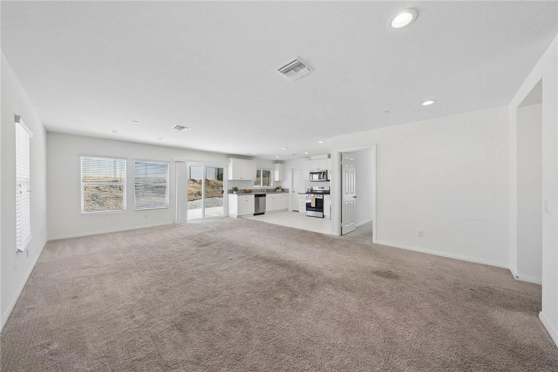 20130 Curaco Court Riverside, CA 92507 - Photo 11 of 43 Open living area with carpeting, recessed lighting, and kitchen access.