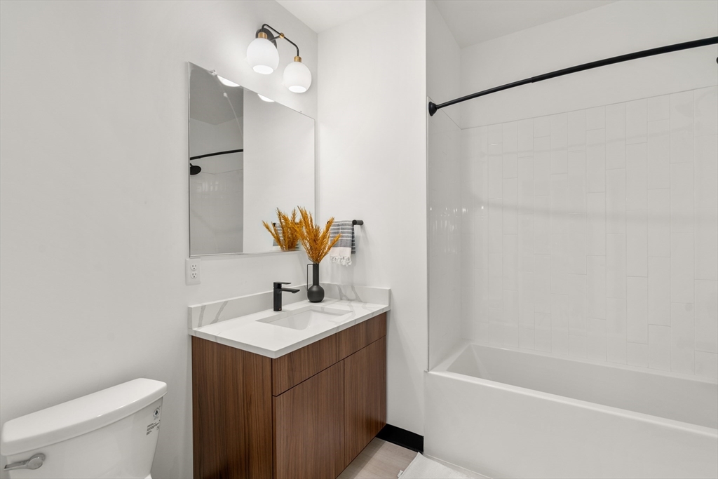 600 Broadway, Unit 612 Chelsea, MA 02150 - Photo 12 of 30 a bathroom with a sink toilet a mirror and shower