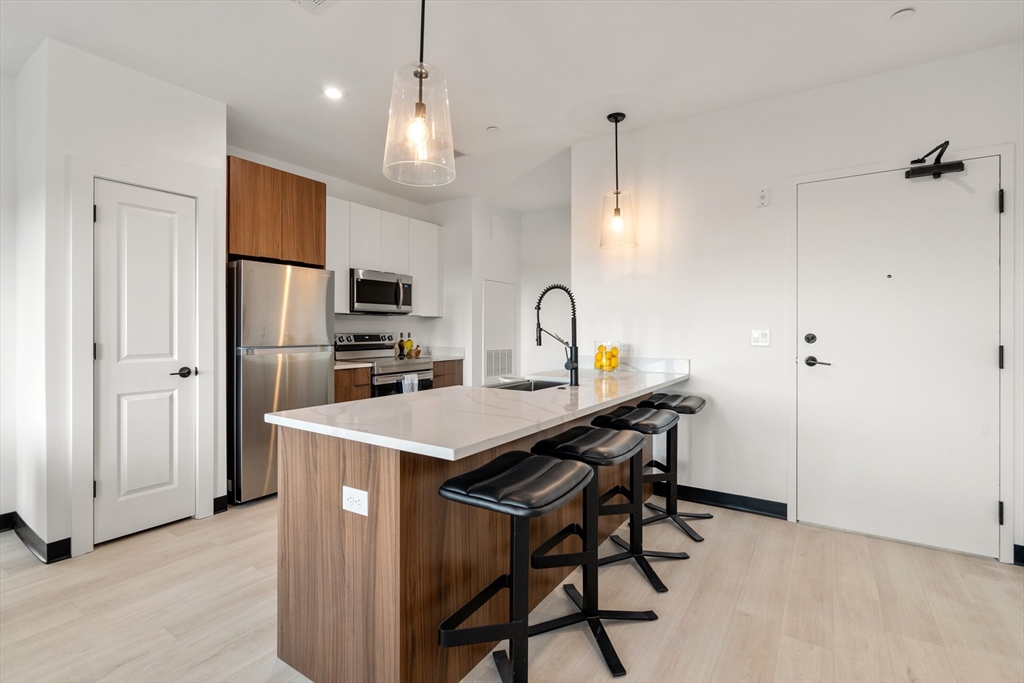 600 Broadway, Unit 612 Chelsea, MA 02150 - Photo 2 of 30 a kitchen with stainless steel appliances a refrigerator and a stove top oven