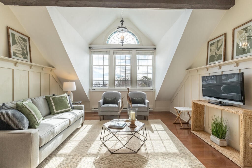 8 Summer Street, Unit 415 Gloucester, MA 01930 - Photo 17 of 32 a living room with furniture a flat screen tv and a floor to ceiling window
