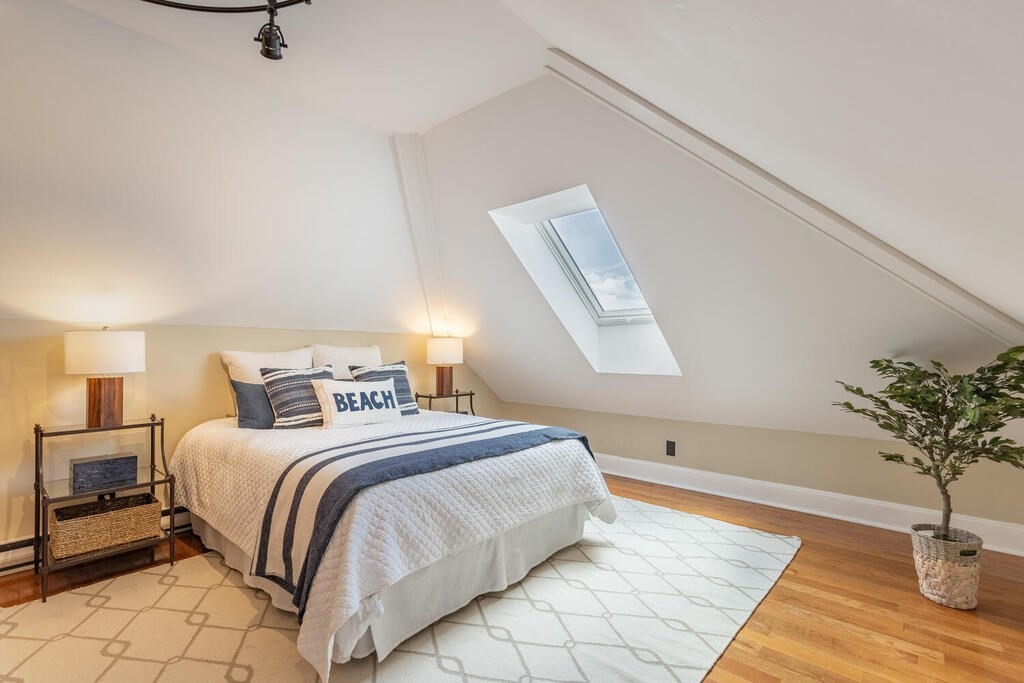 8 Summer Street, Unit 415 Gloucester, MA 01930 - Photo 29 of 32 a bedroom with a large bed and a potted plant on the dresser