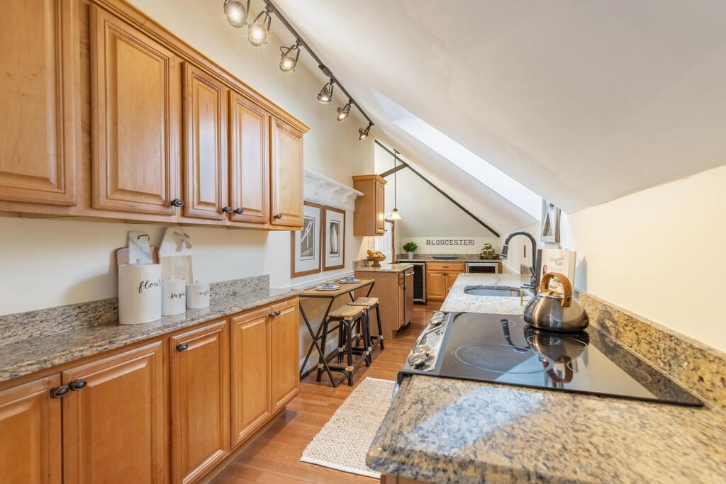 8 Summer Street, Unit 415 Gloucester, MA 01930 - Photo 8 of 32 a kitchen with stainless steel appliances granite countertop a sink dishwasher and cabinets with wooden floor