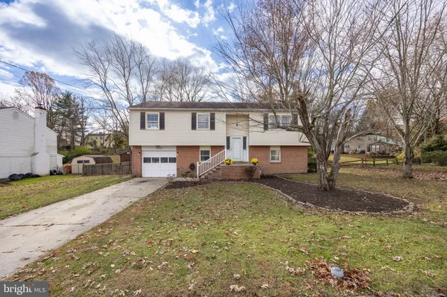 a white house that has a tree in front of it